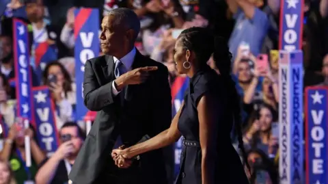 Barack and Michelle Obama Electrify Democrats but Warn of Tight Race